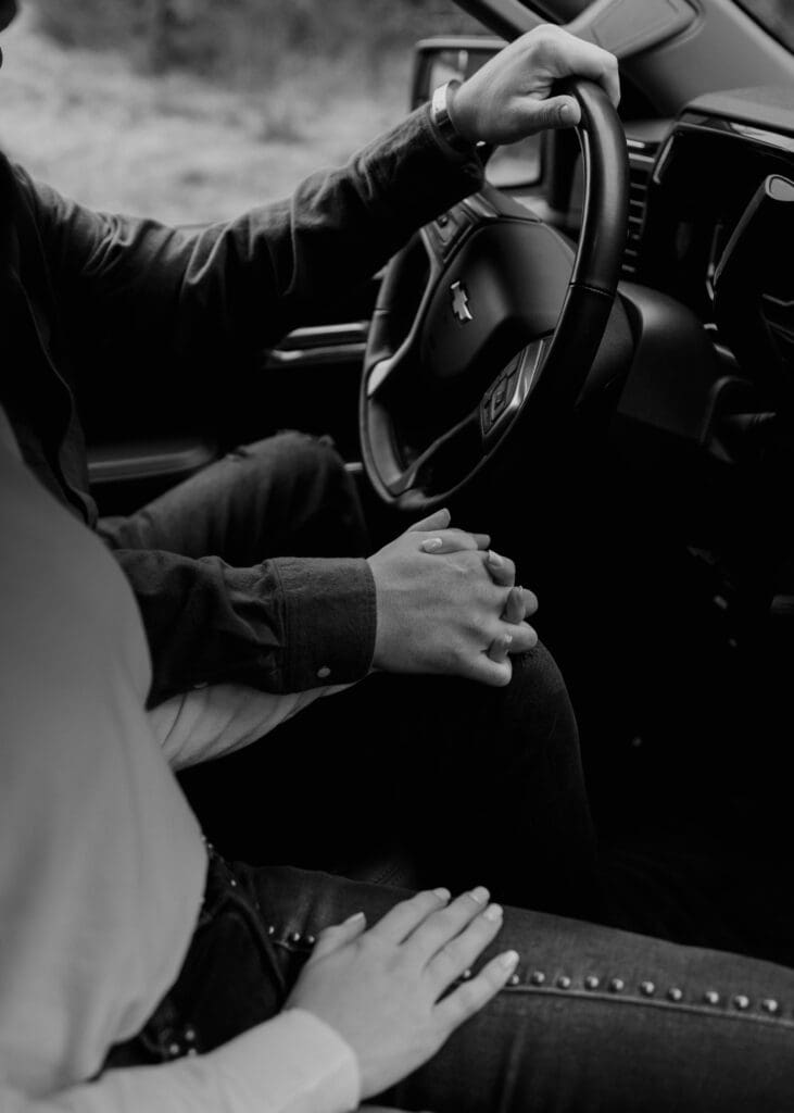 couple holding hands in a truck