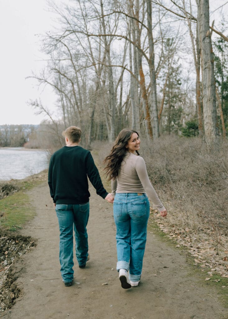 couple walking down a trail and woman turning back 