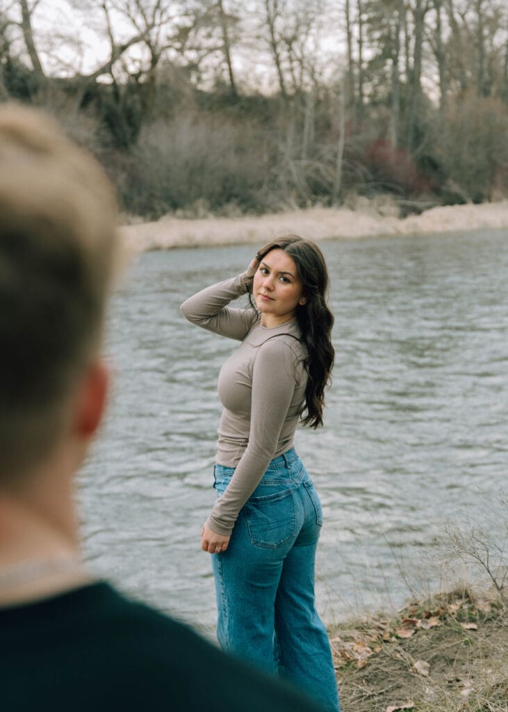 over the shoulder shot by the river with girl posing 