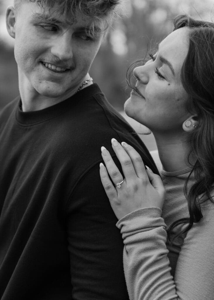 black and white photo of engaged couple looking at eachother 