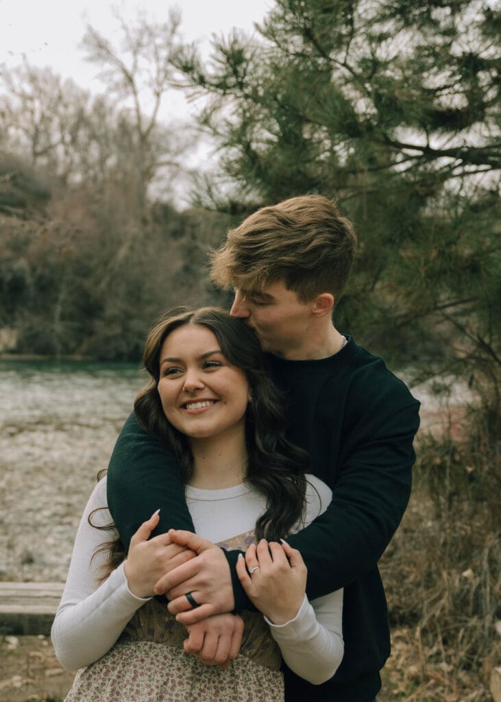man kissing top of girlfriends head during engagement session at yakima river 
