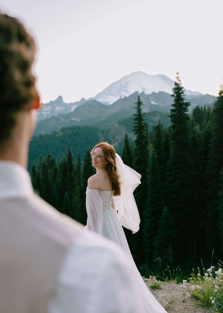 groom admiring his bride in front of Mt. Rainier 