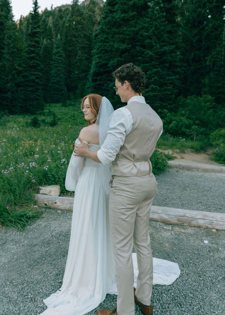 groom helping bride get ready for Mt Rainier elopement