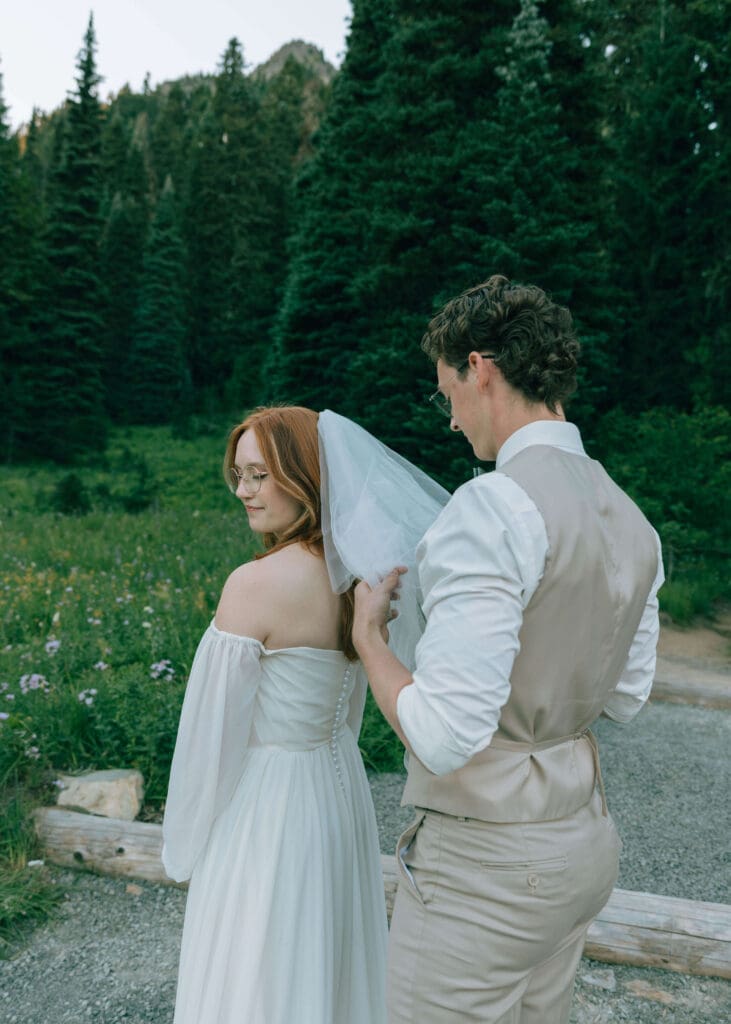 groom fixing brides veil at Mt Rainier national park elopement