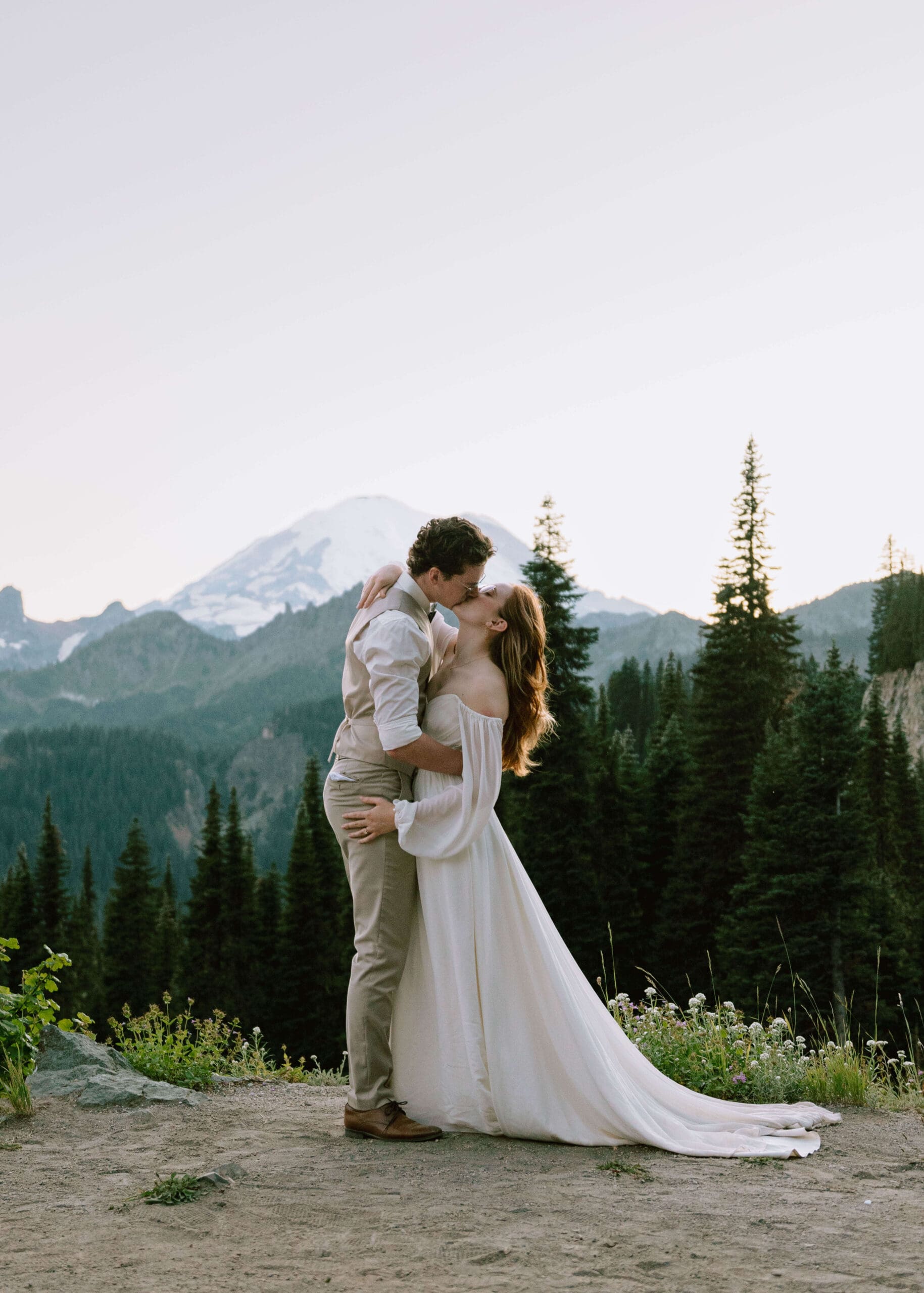 bride and groom kissing in front of Mt Rainier at blue hour at Lake Tipsoo