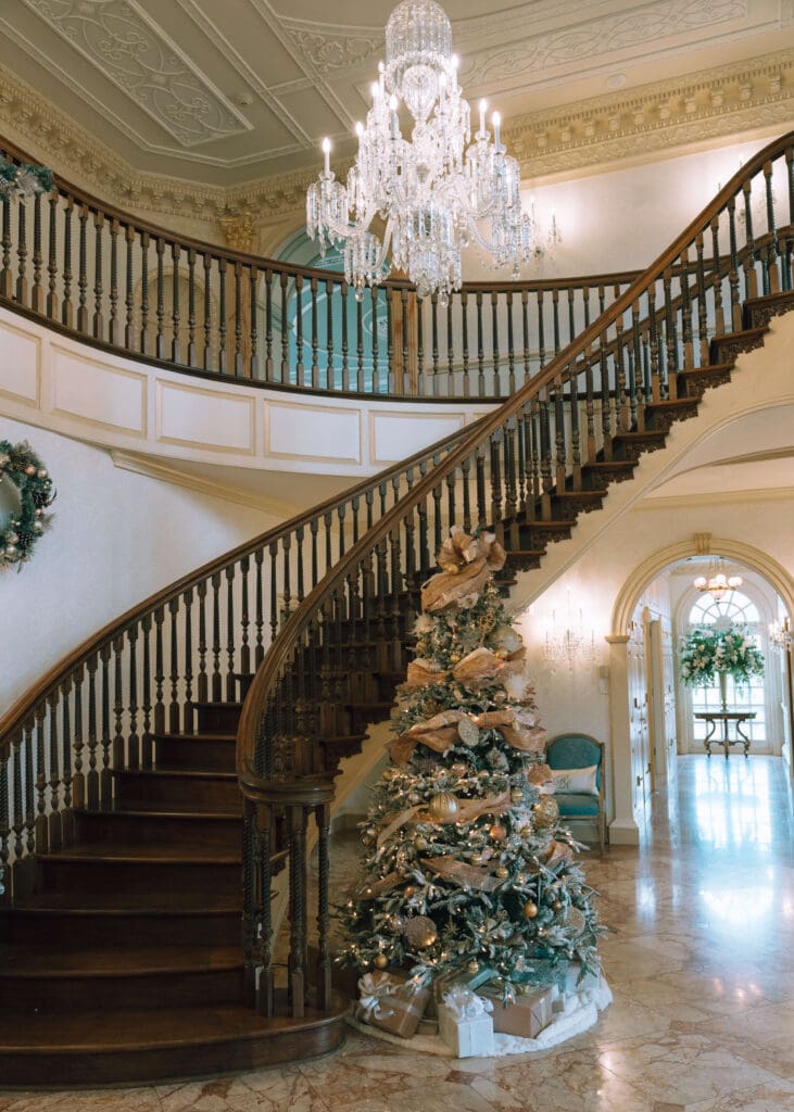 grand staircase at the estate at river run with christmas tree and chandelier 