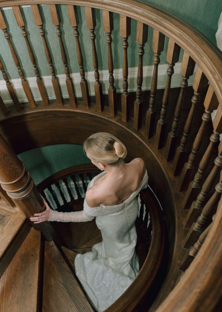 bride walking down the spiral stairs at estate at river run