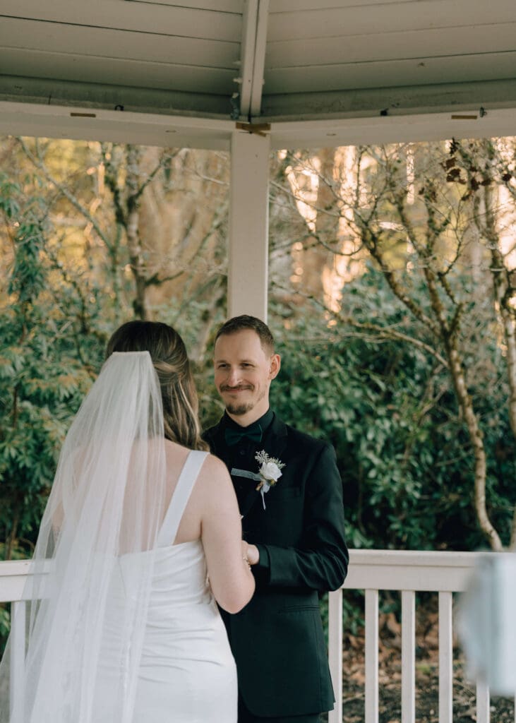 groom looking at bride getting emotional during private vows under the gazebo at Issaquah barn wedding 