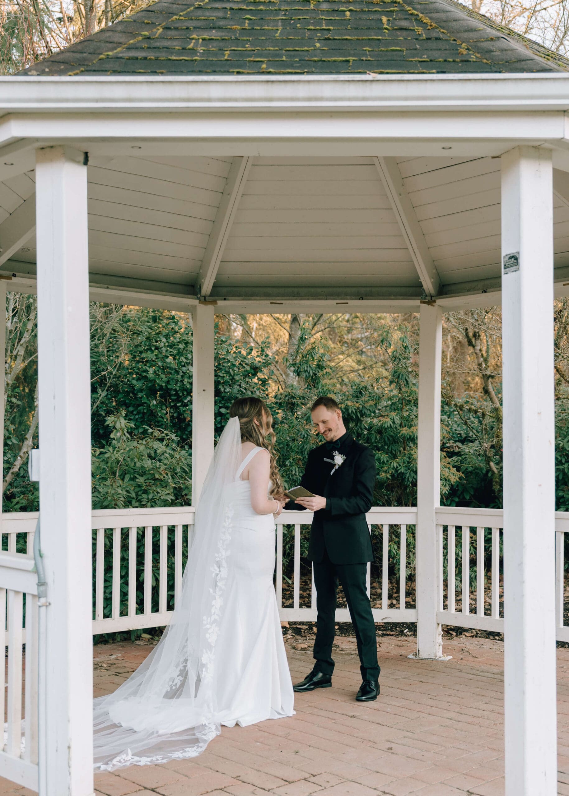 bride and groom standing under white gazebo at Issaquah barn wedding