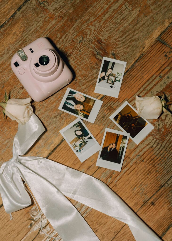 polaroids, white bow, and pink polaroid camera with white rose at Issaquah barn wedding 