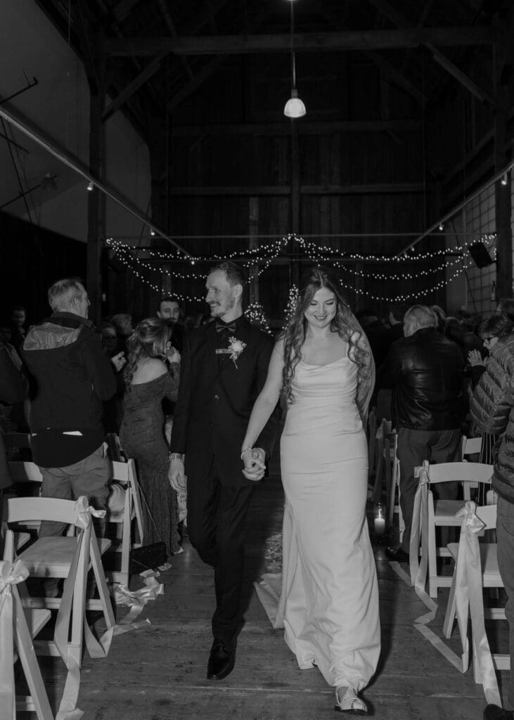 bride and groom holding hands and walking down the aisle after the wedding ceremony 