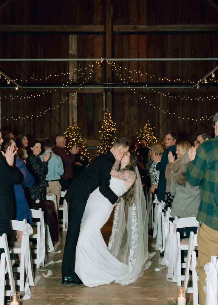 bride and groom kissing in the aisle after their wedding ceremony at issaquah barn wedding 