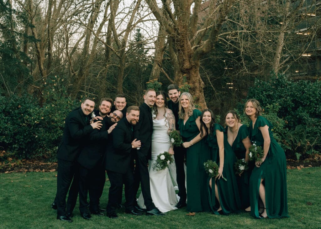 casual group photo of bridal party in green and black clothes outside at Issaquah barn wedding 