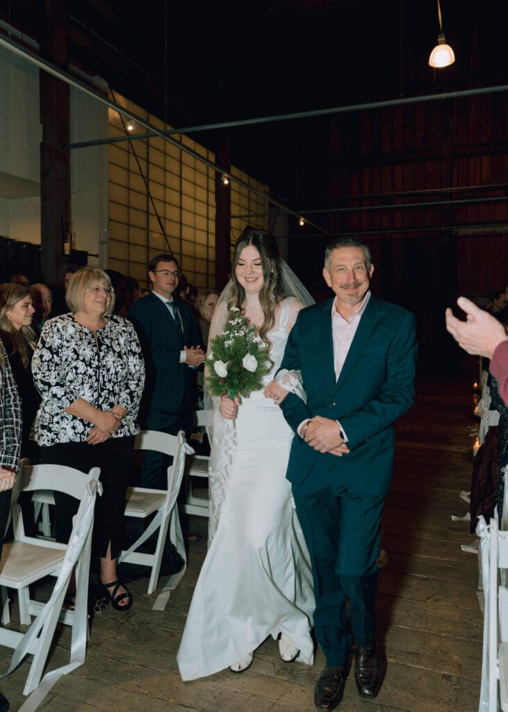 bride walking down the aisle with her father at Pickering Barn 