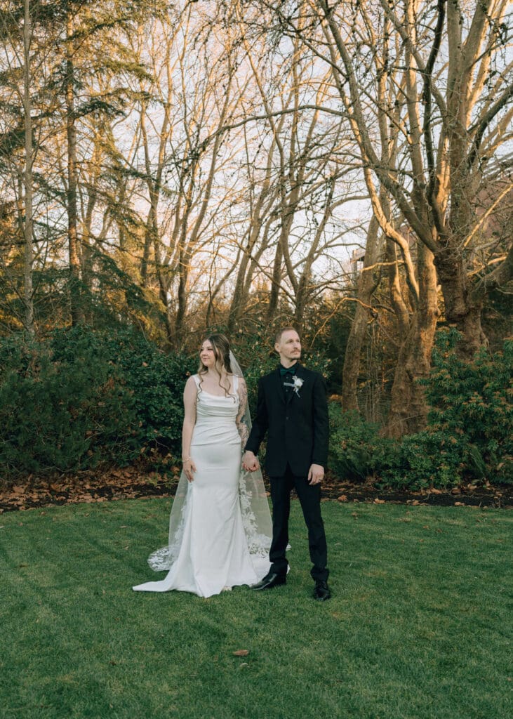 bride and groom holding hands and looking away from each other outside at Pickering Barn during sunset