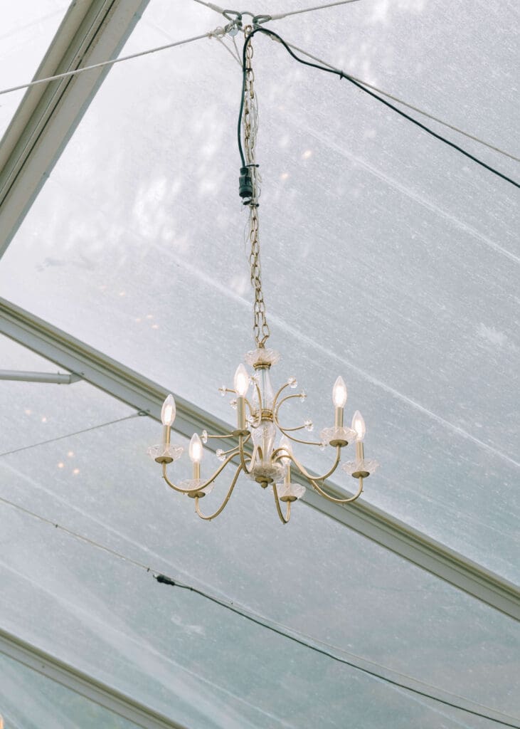 chandelier at the top of the glass ceiling on outdoor reception space at a fox hollow farm wedding