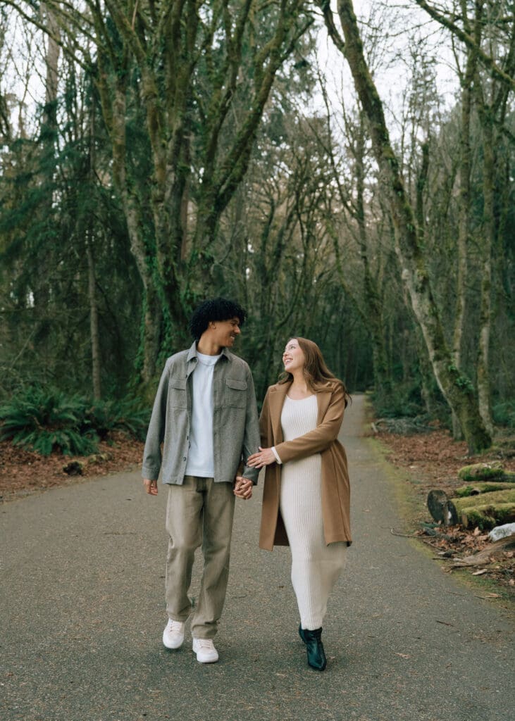 couple holding hands and looking at each other while walking at Owen Beach 