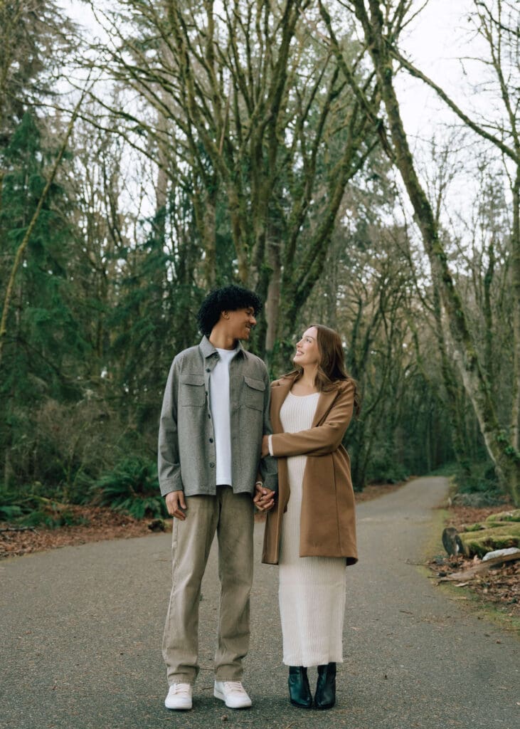 couple holding hands and looking at each other at Point Defiance Park 