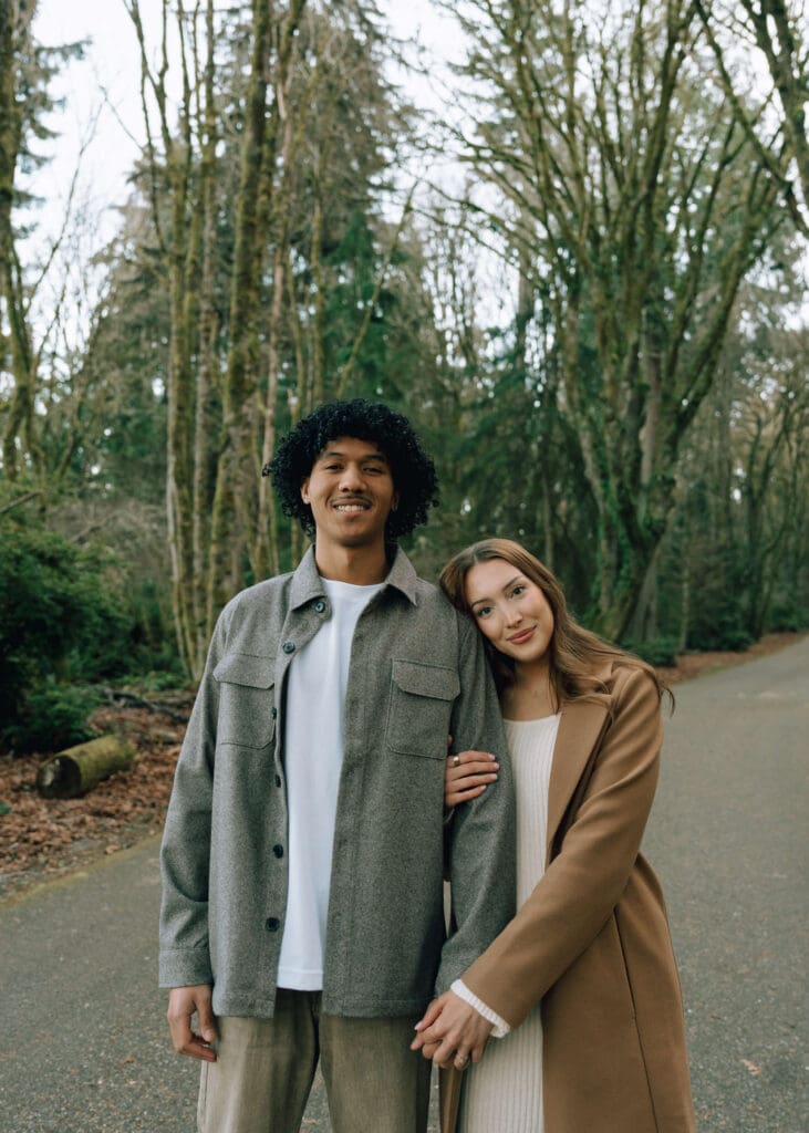 woman leaning her head on partner's shoulder and holding hands on a road in Point Defiance 