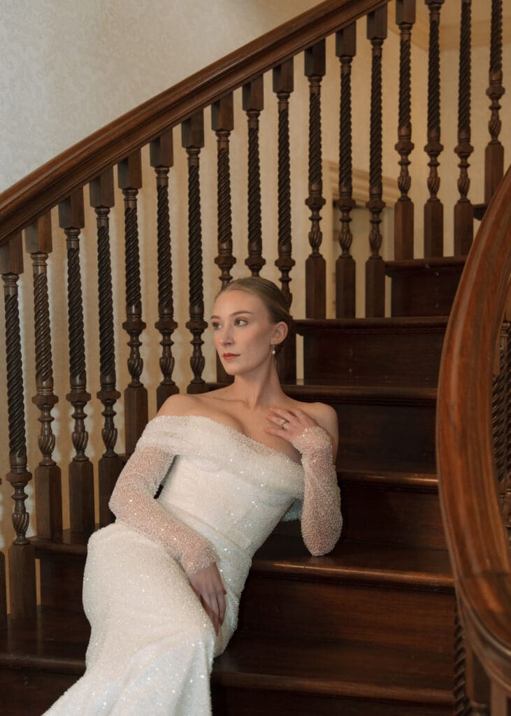 bride leaning against stairs touching her chest- reasons to get bridal portraits done