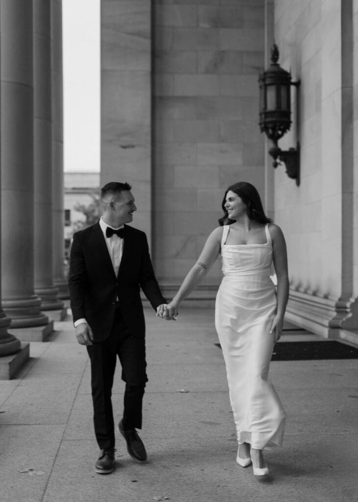 couple holding hands and walking outside the capitol building in Olympia 