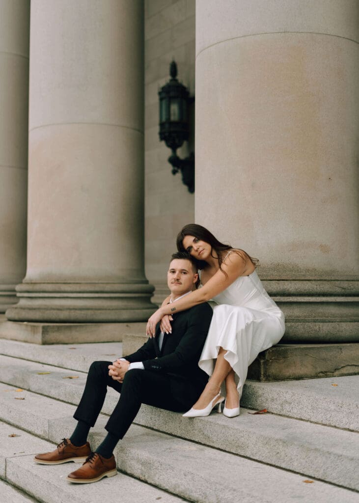 bride leaning on groom sitting on steps at washington state capitol wedding 