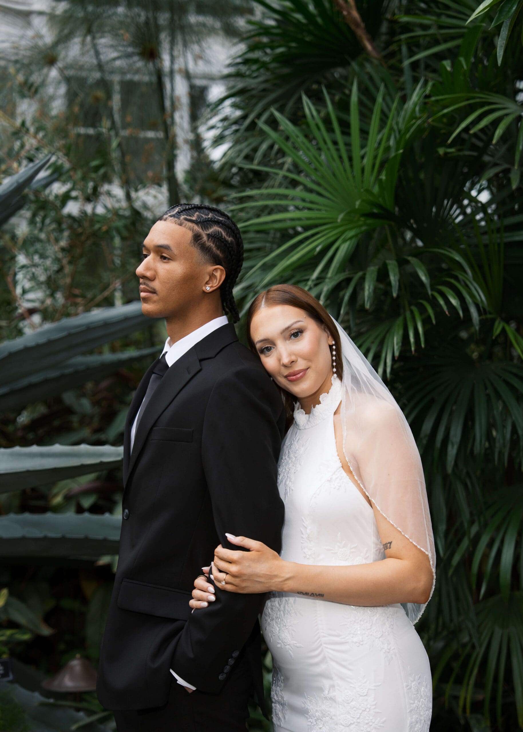 bride leaning her head on groom's shoulder at greenhouse microwedding