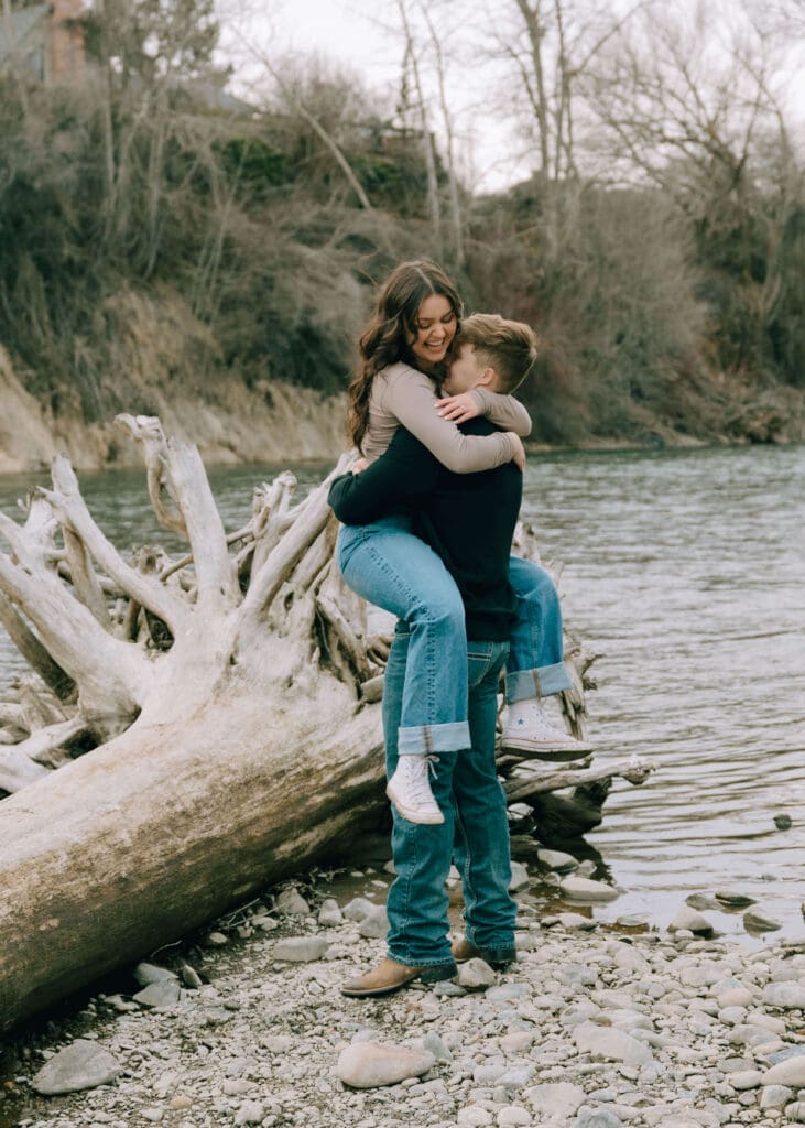 woman jumping into boyfriend's arms in front of the river at engagement photo locations in washington state
