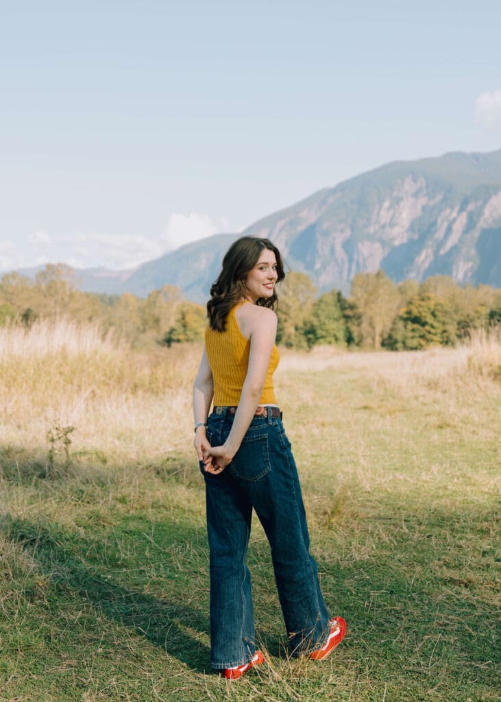 high school senior at Steilacoom High School hands behind her back and looking over her shoulder 
