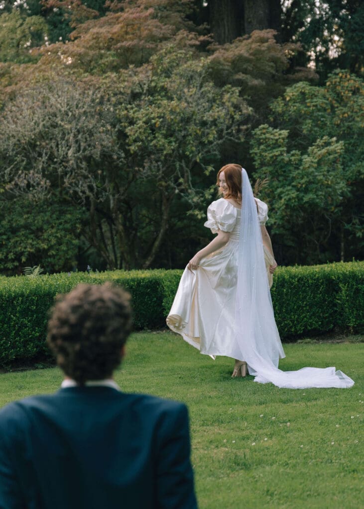 bride looking over her shoulder at the groom on the garden wedding venue