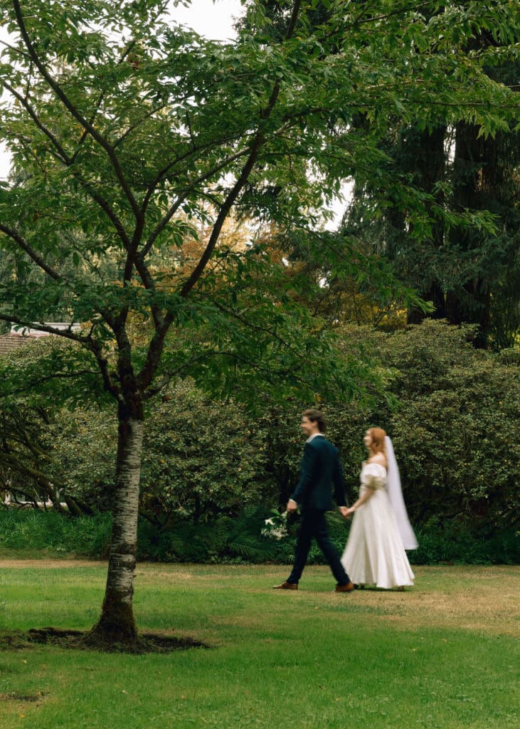 bride and groom holding hands and walking in the garden at Thornewood castle wedding 