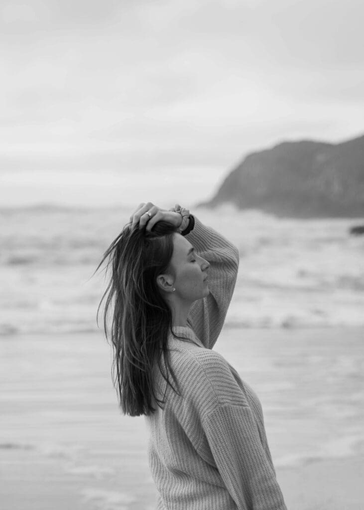 cannon beach elopement photographer pushing hair back at the beach