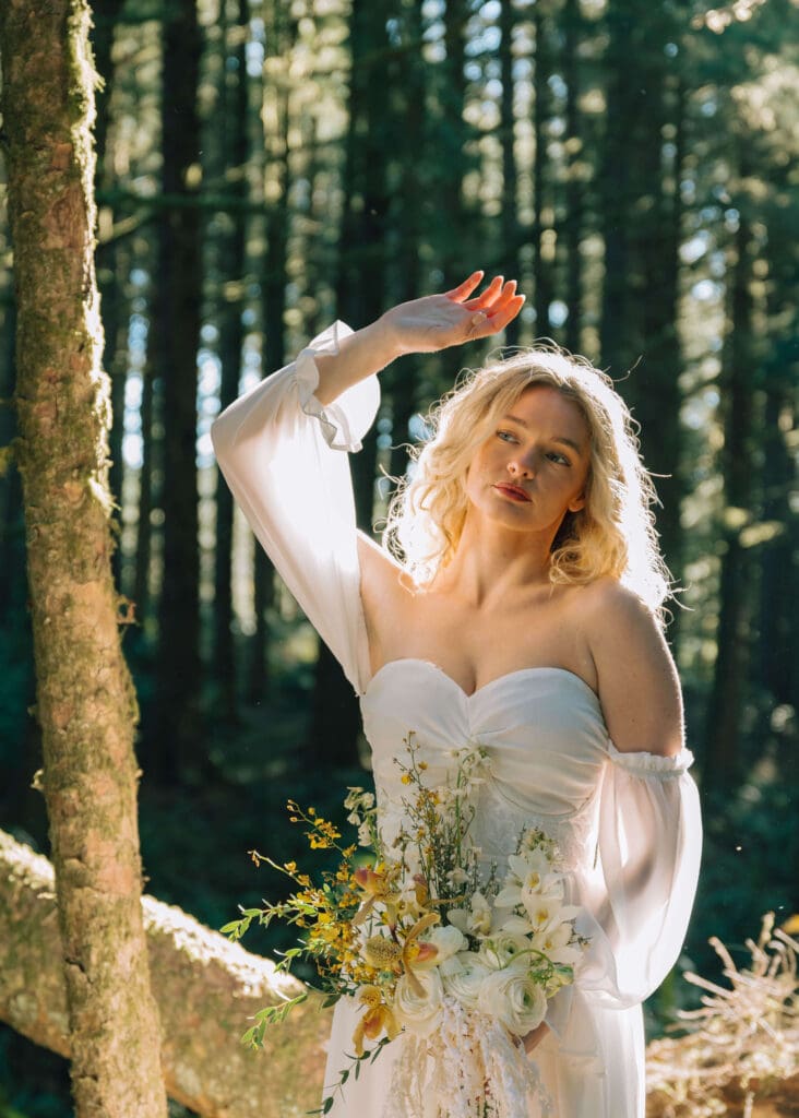 bride with her hand up blocking the sun by cannon beach elopement photographer