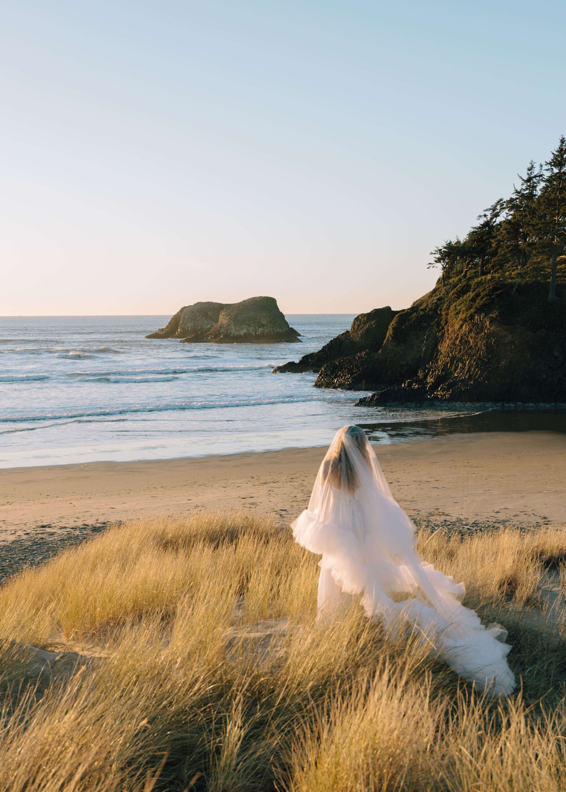 bride looking at the ocean by cannon beach photographer