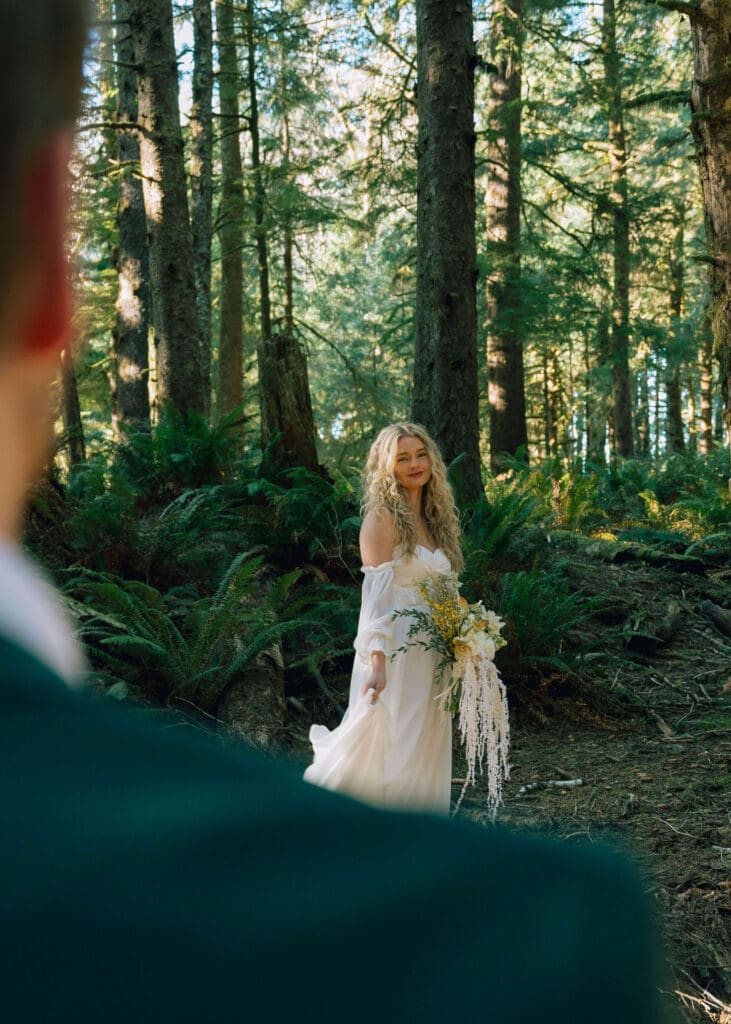 bride looking at groom in the forest by Ecola state park elopement photographer