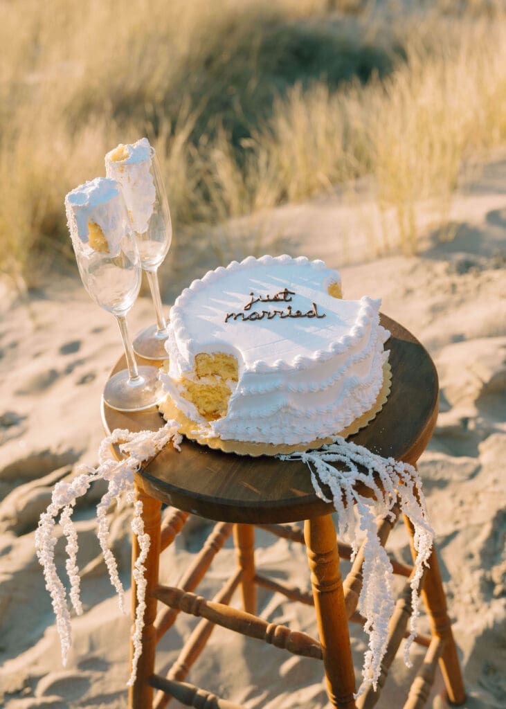 cake with 2 pieces taken out at sunset by Oregon coast elopement photographer