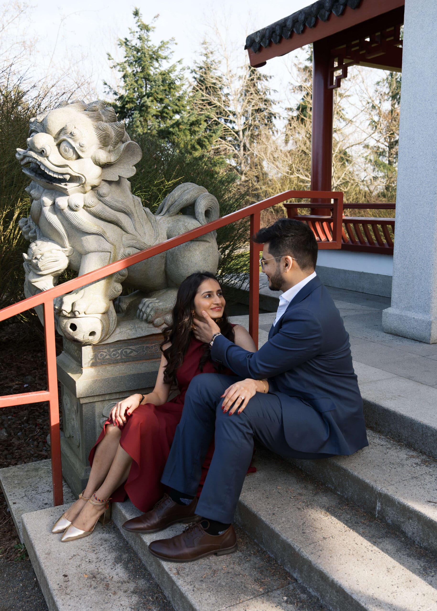 man cupping partner's face while they sit on the stairs outside at Tacoma photo location