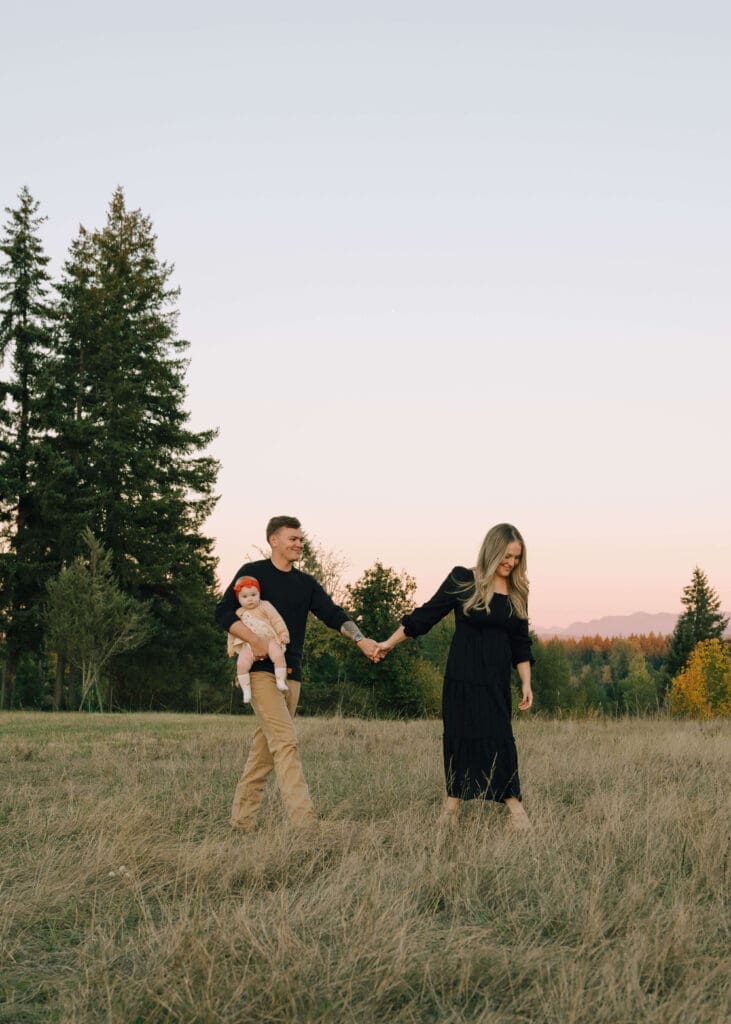 couple walking across a field at sunset at Tanwax Country chapel