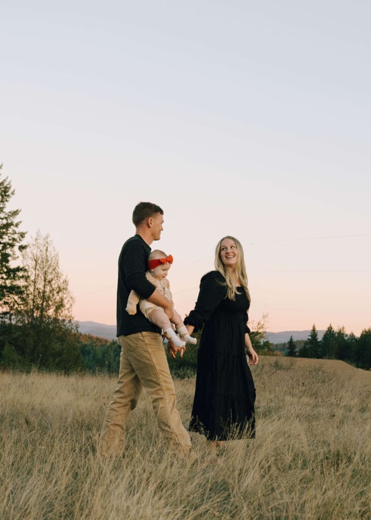 parents walking and holding hands in a field for Tanwax Country chapel family photos 
