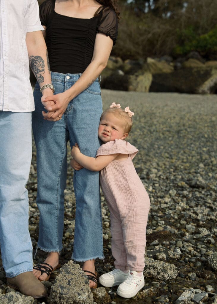 toddler hugging moms leg on Titlow beach 