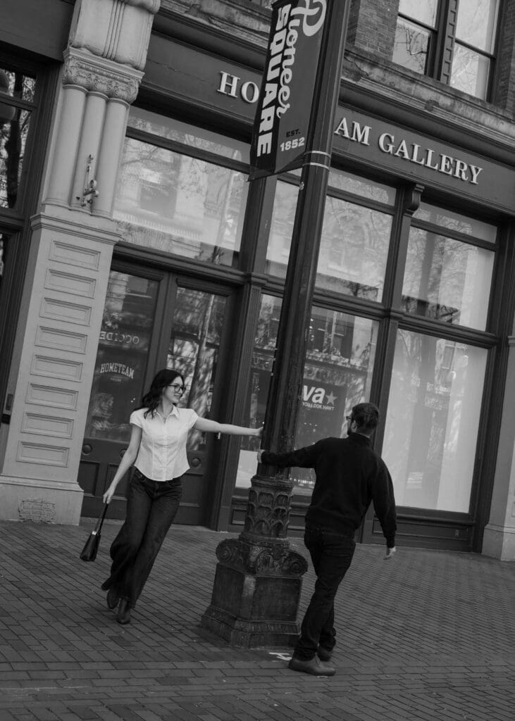 couple swinging around light post for Seattle engagement photo locations