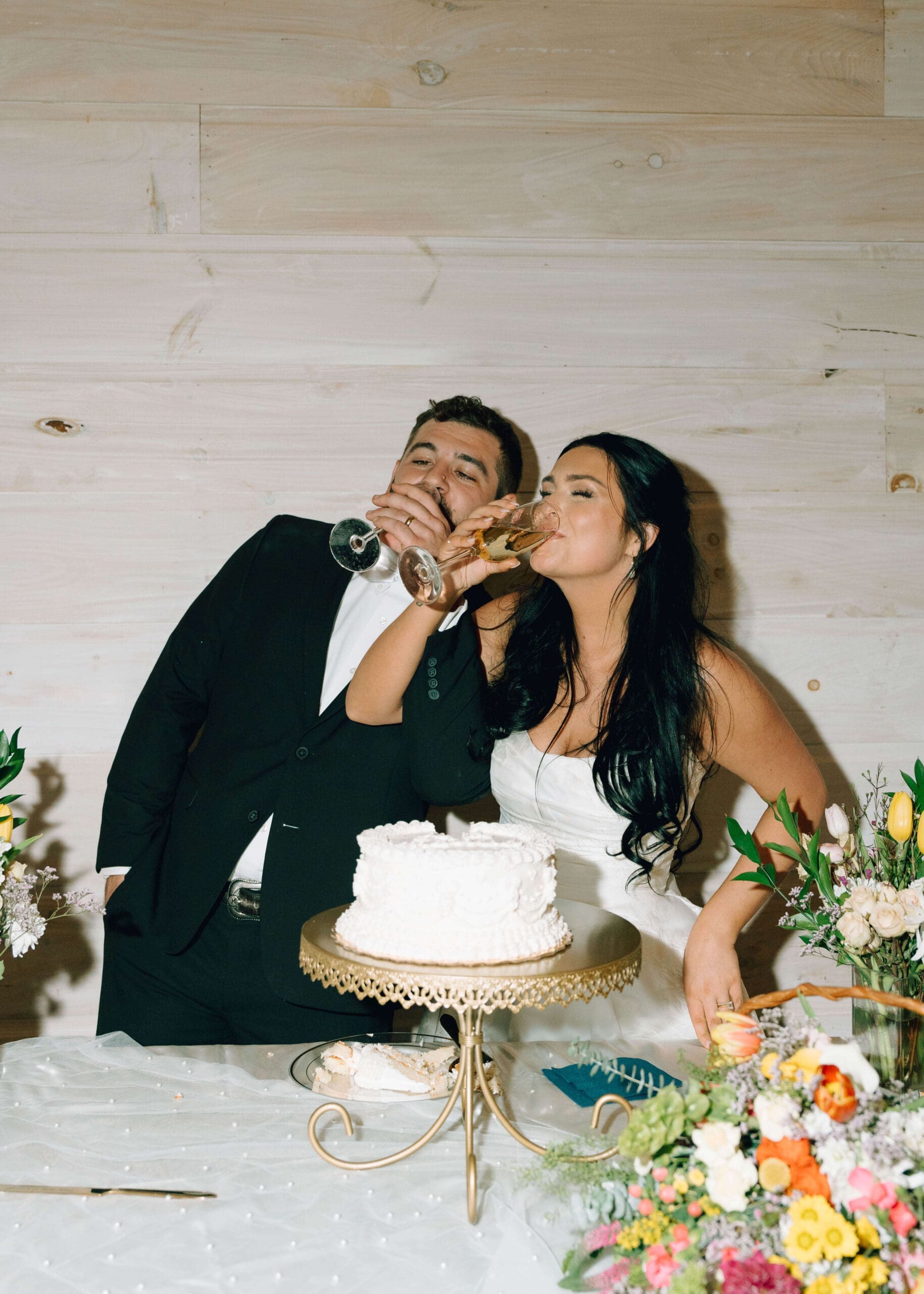 bride and groom drinking champagne after cutting the cake at Silver Cloud Hotel