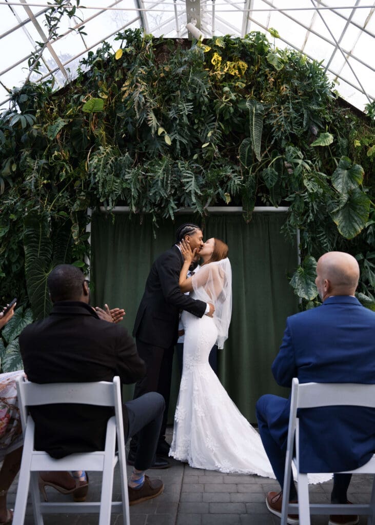 man and wife's first kiss after wedding ceremony at Volunteer Park Botanical Conservatory 