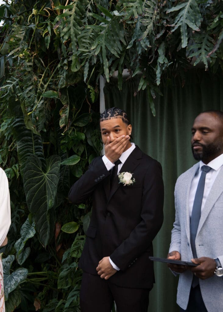 groom getting emotional at wedding ceremony seeing his bride walk down the aisle at Volunteer Park conservatory wedding