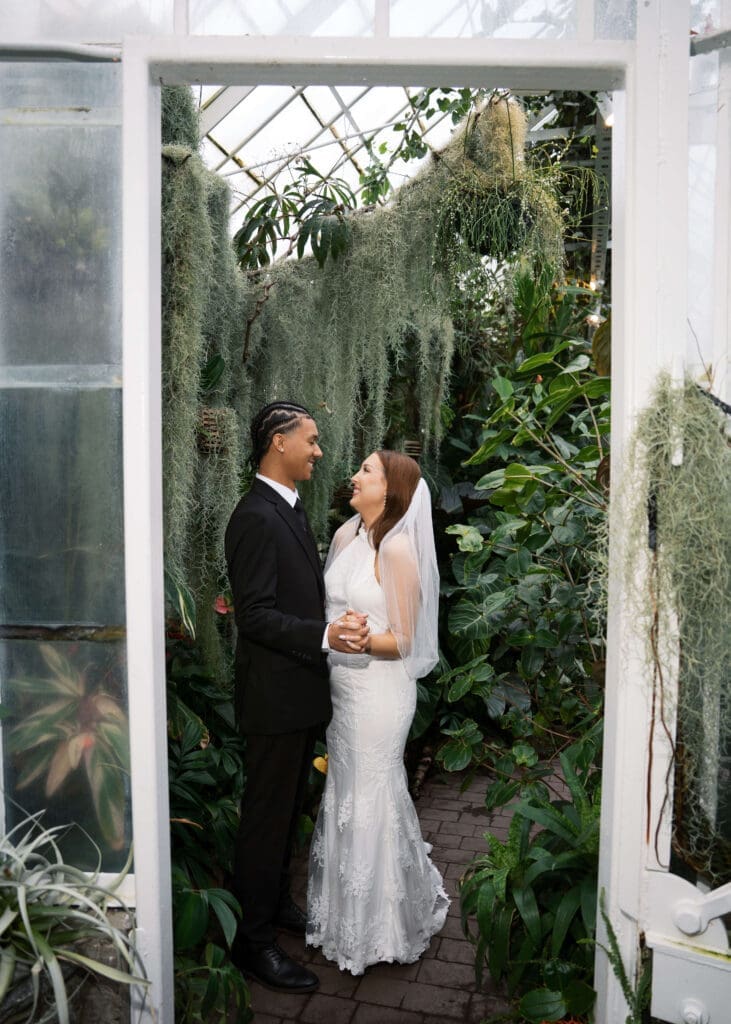 couple holding hands and looking at each other smiling at Volunteer park conservatory wedding