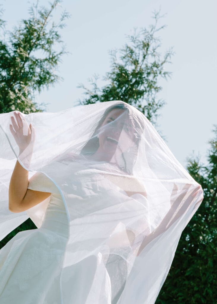 bride smiling underneath her veil on her wedding day at Bibb Mills Event Center