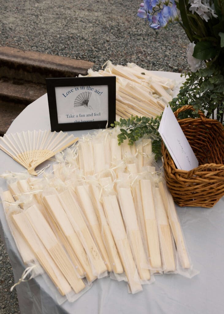 fans set out as wedding favors at summer outdoor wedding
