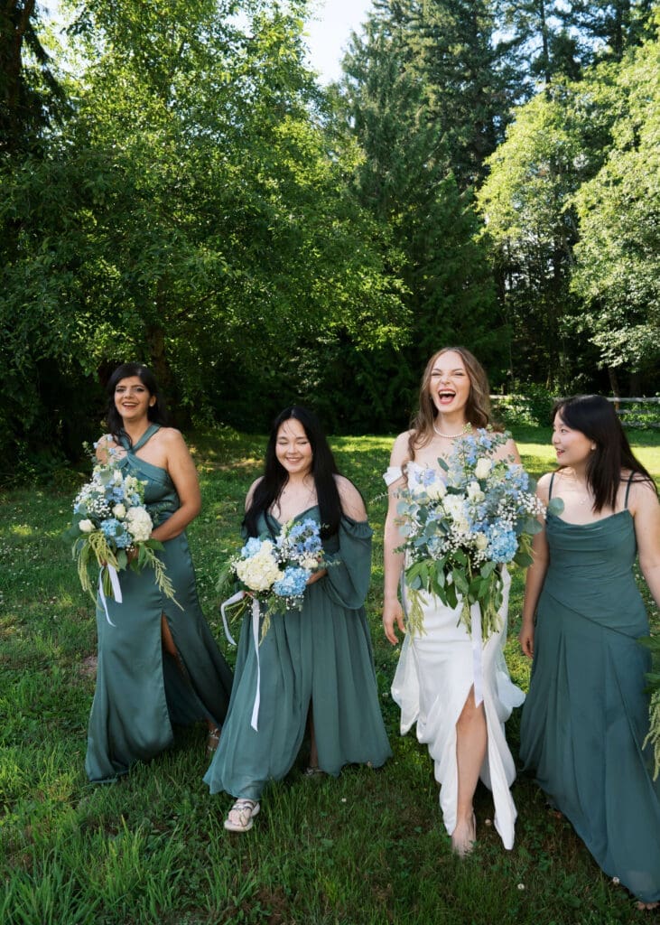 bride laughing with her bridesmaids in green dresses at outdoor summer wedding in Georgia