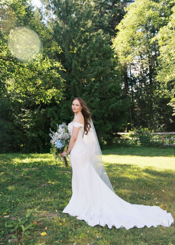 bride posing alone with her bouquet and the wind in her hair at Georgia wedding