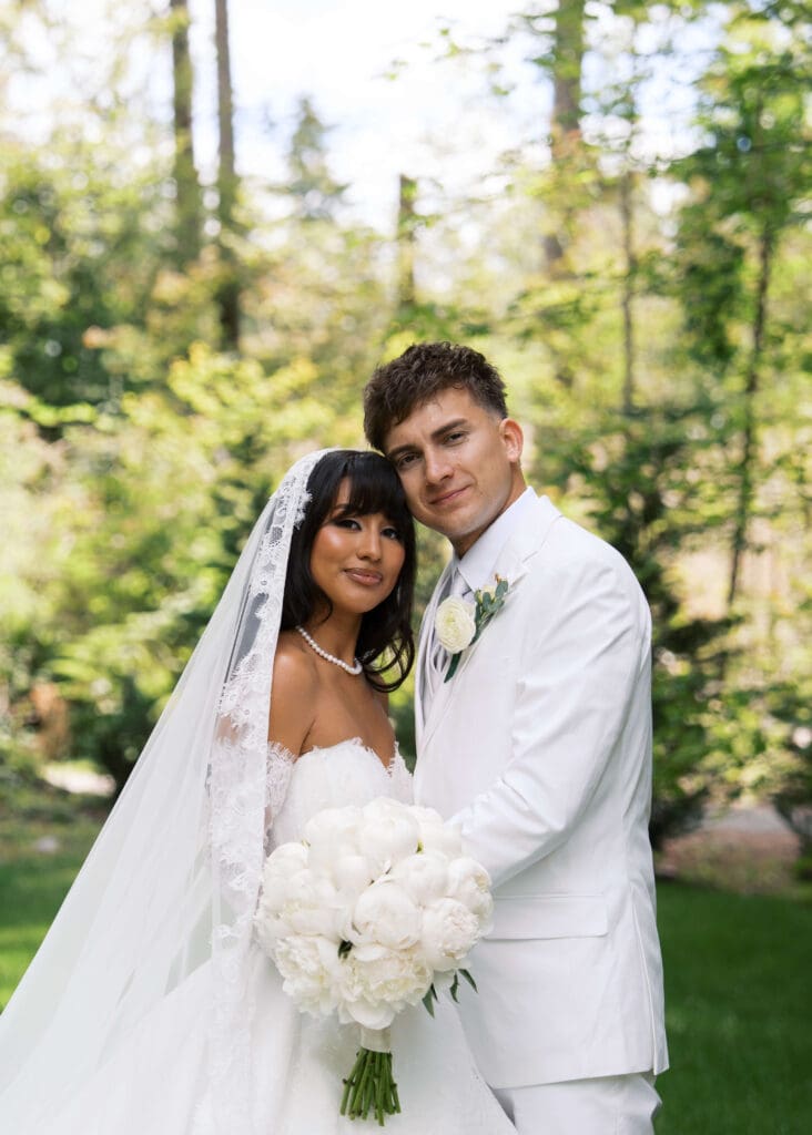 couple cheek to cheek on their wedding day in wedding attire outside Hidden Stone Palace